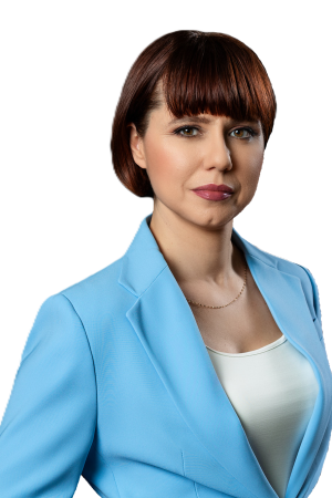 Zdjęcie przedstawiające Notariusza Magdalenę Kułaj, ubraną w niebieską marynarkę i białą podkoszulkę.
