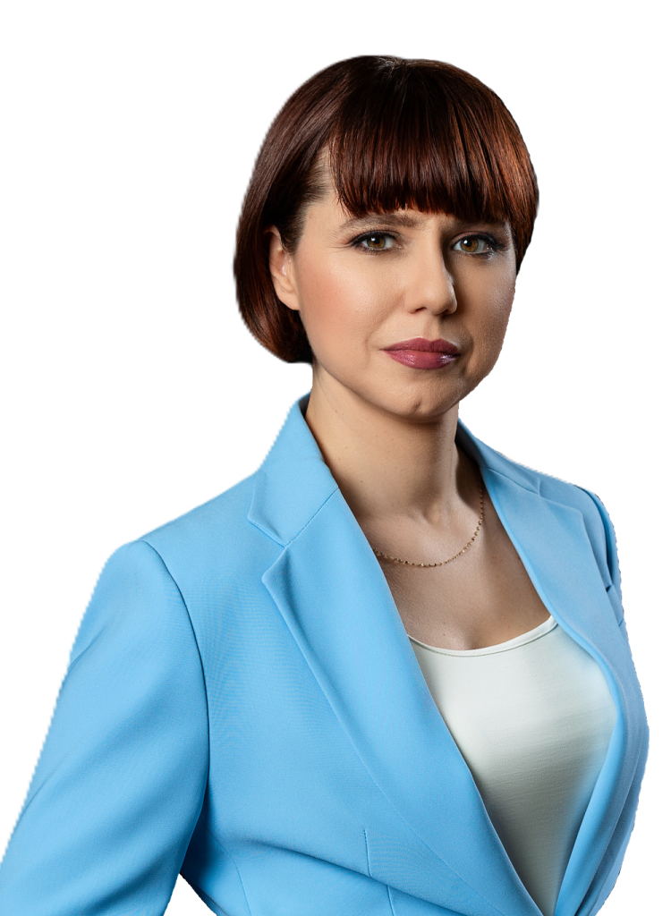 Notariusz Magdalena Kułaj Zdjęcie przedstawiające Notariusza Magdalenę Kułaj, ubraną w niebieską marynarkę i białą podkoszulkę.